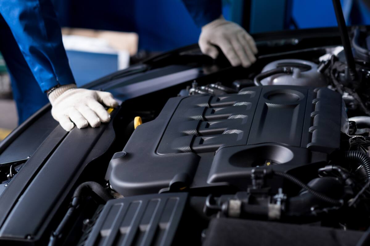 Technician in gloves working over an engine bay