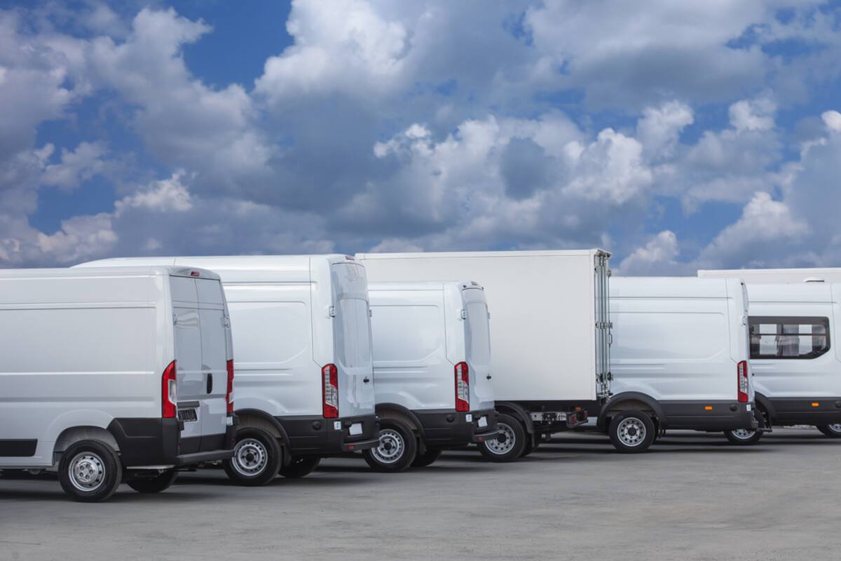 Row of white fleet vans parked together
