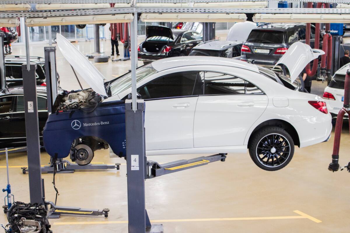 White Mercedes raised on a workshop lift