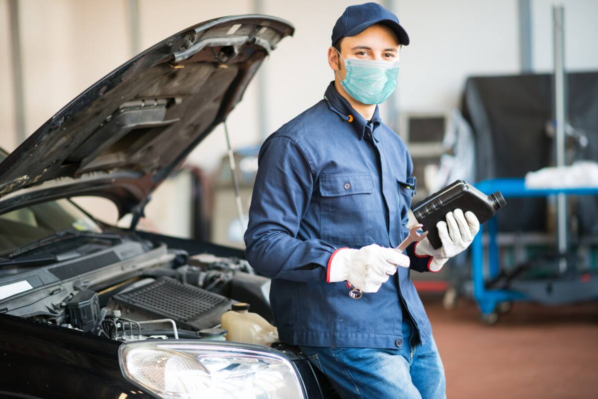 Technician with a tablet beside an open engine bay