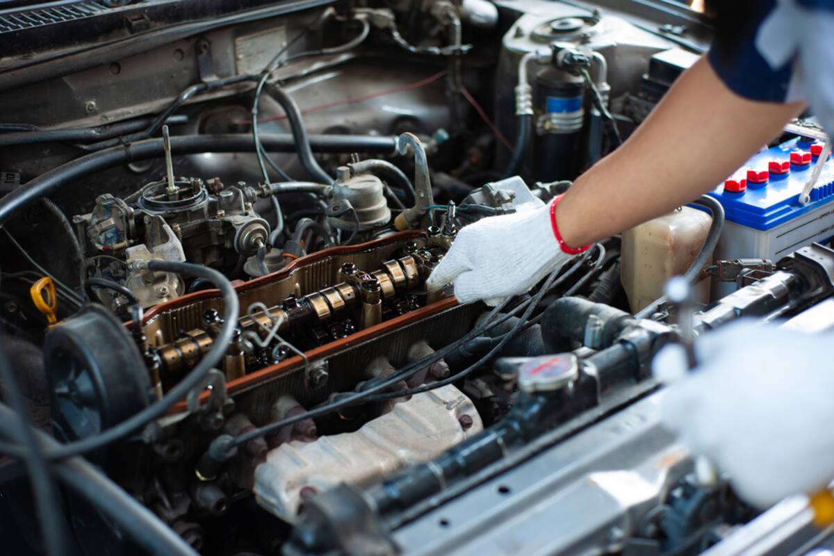 Technician working inside an engine bay