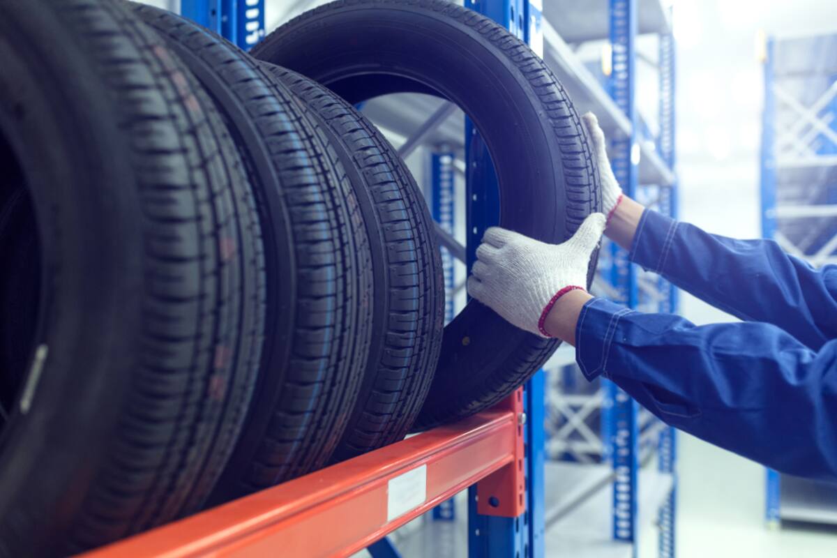 Technician handling tires on a storage rack