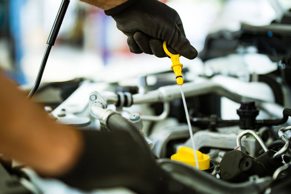 Technician checking the engine oil dipstick