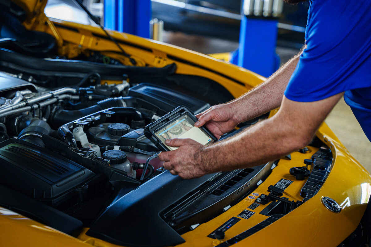 Autobahn technician working through an engine bay with a tablet