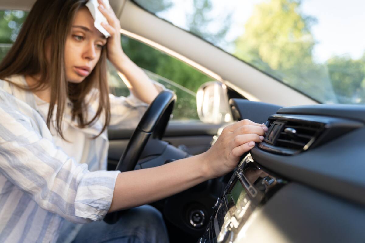 Driver fanning herself in a hot car