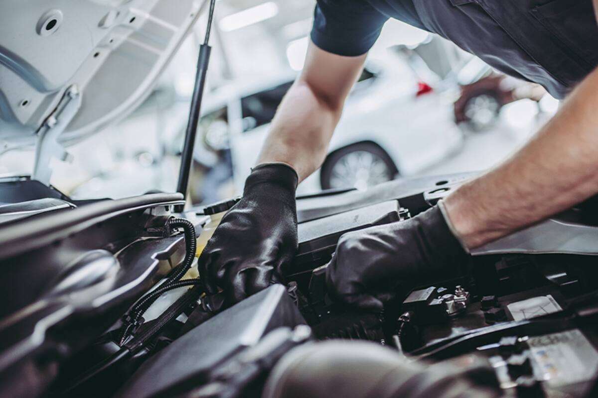 Technician working under the hood of a car