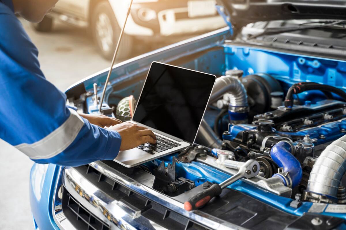 Technician running diagnostics on an engine with a laptop