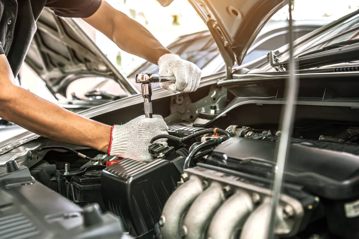 Technician's gloved hands working on an engine