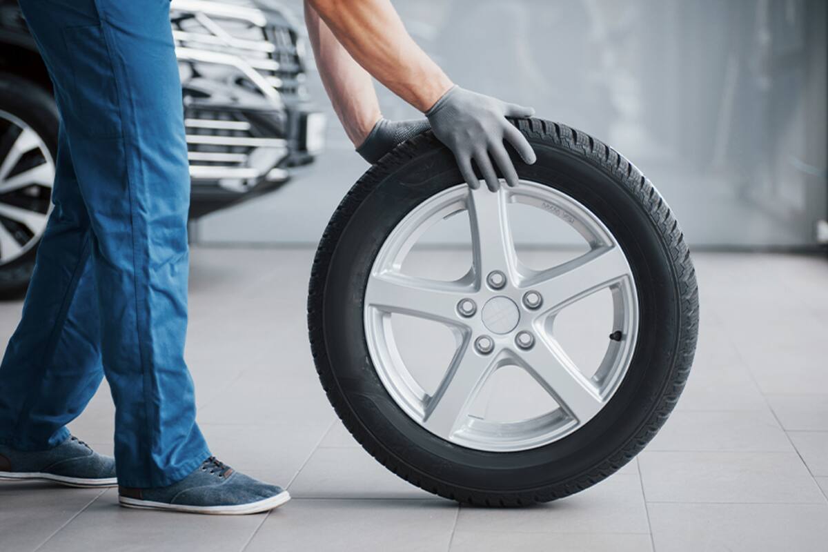 Technician carrying a wheel and tire