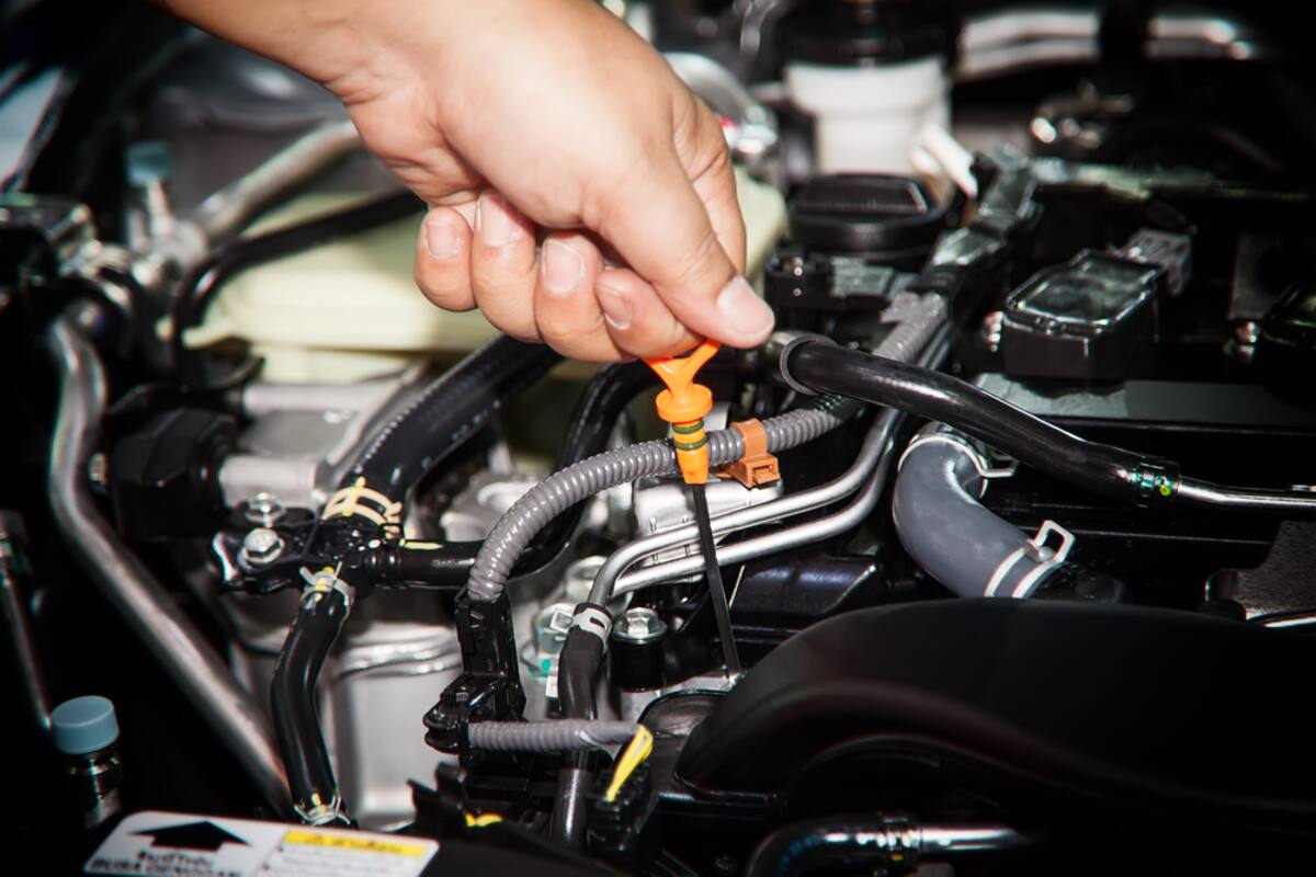 Hand checking an engine oil dipstick