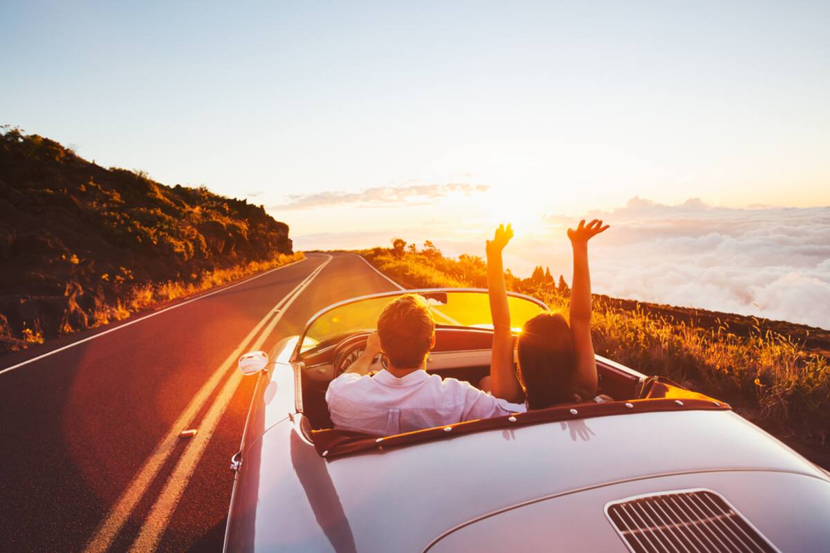 Convertible on a coastal road at sunset