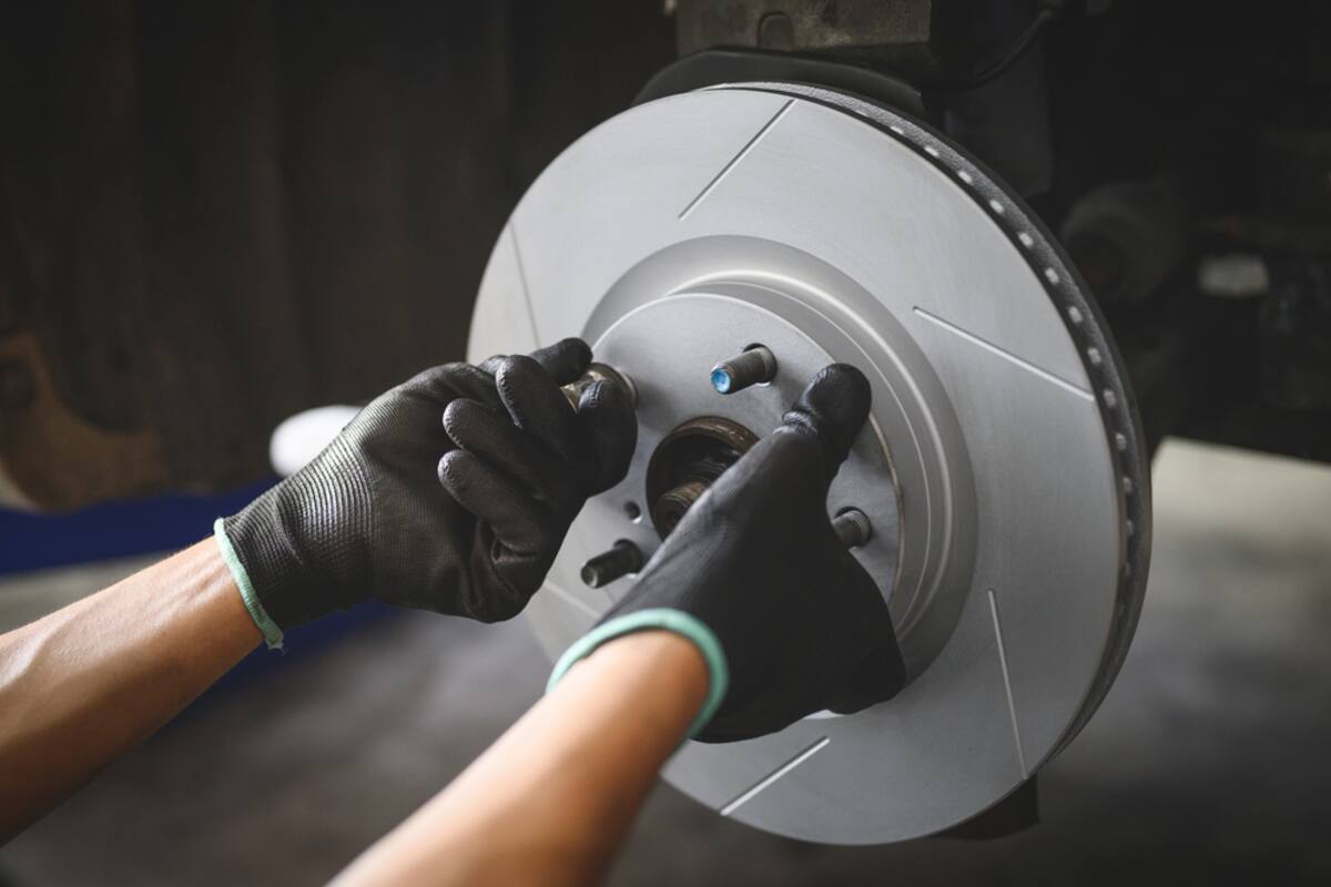 Technician's gloved hands on a brake rotor