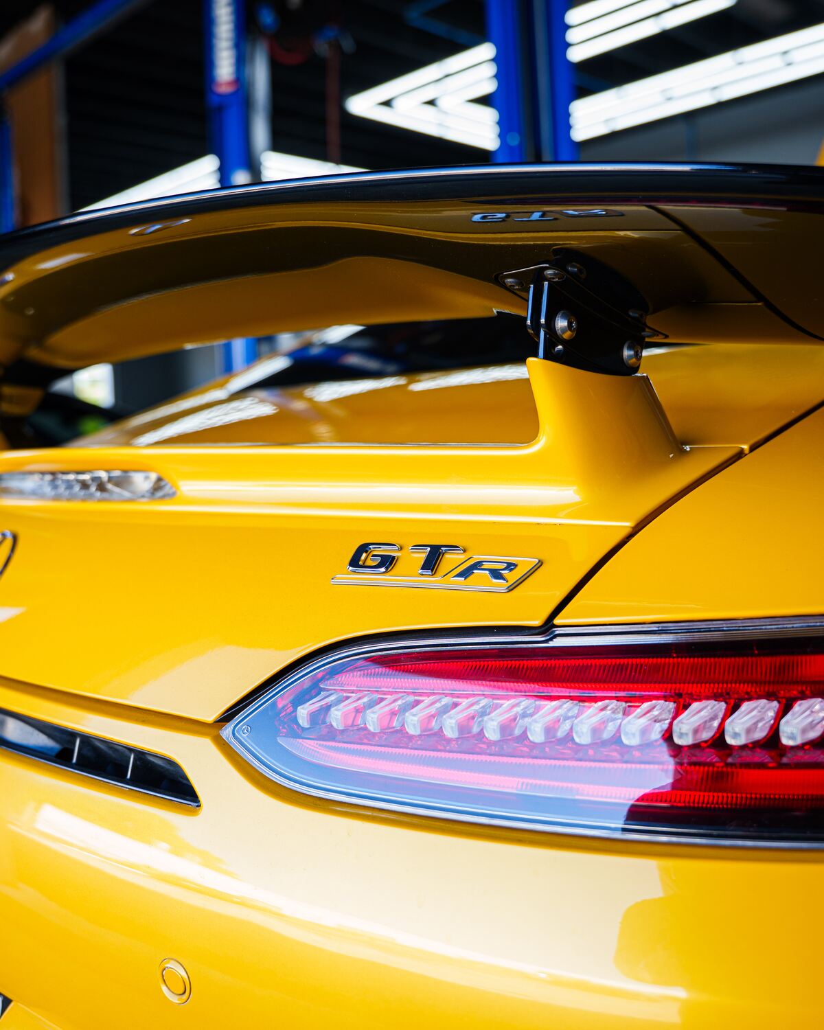 The rear wing and badge of a yellow Mercedes-AMG GT R at Autobahn Auto Center