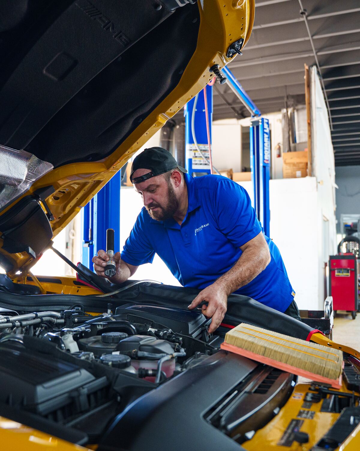 An Autobahn technician working in the engine bay of a Mercedes-AMG GT R