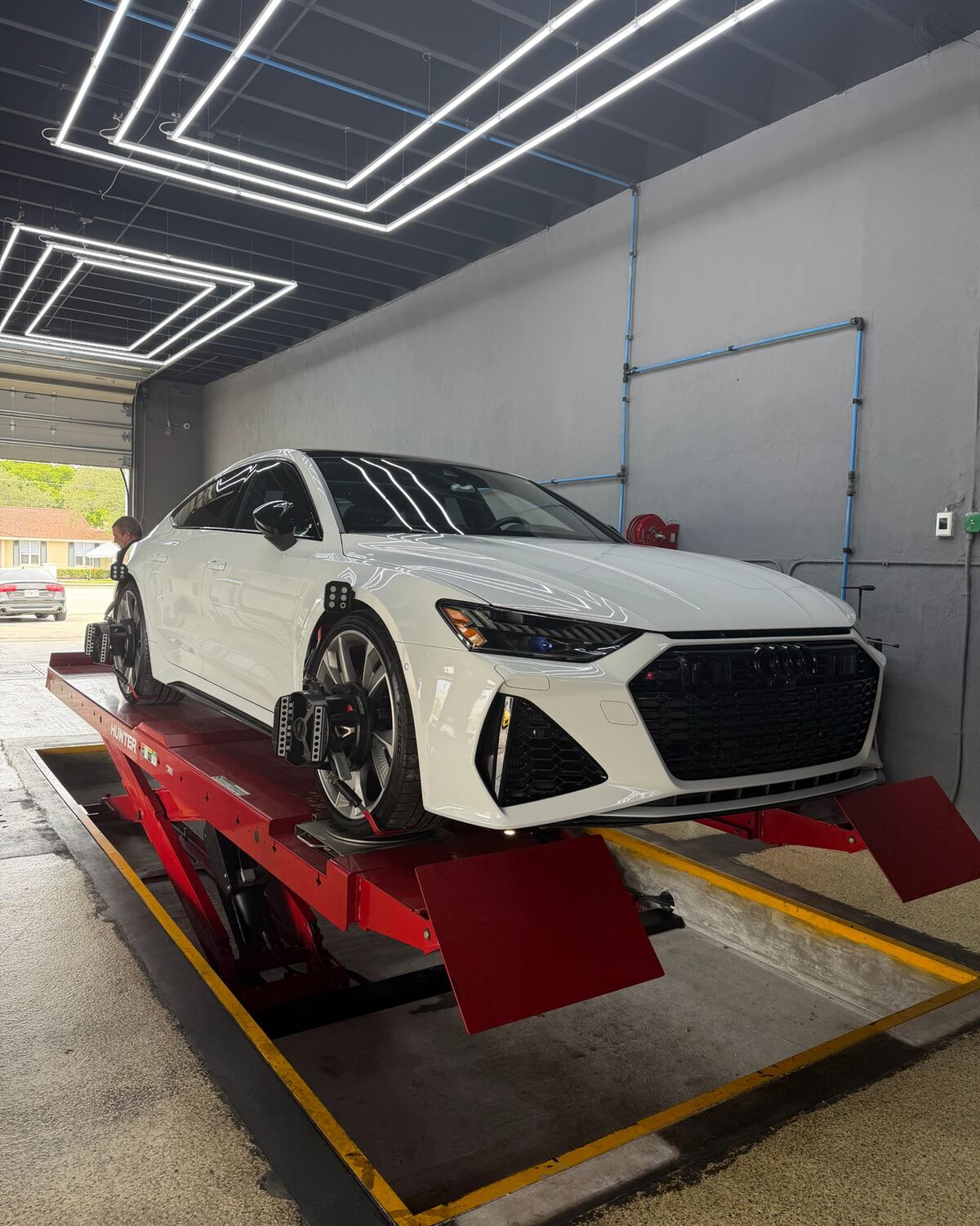 A white Audi RS 7 on the alignment rack at Autobahn Auto Center