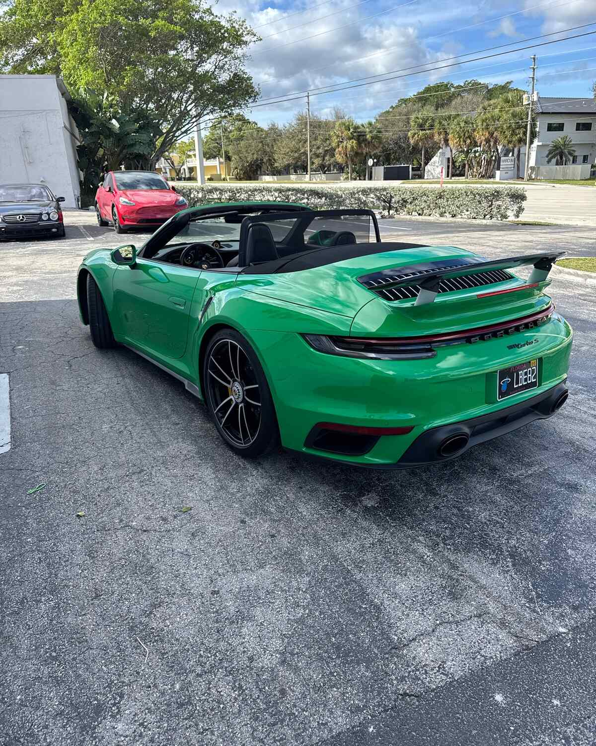 A green Porsche 911 cabriolet parked outside Autobahn Auto Center