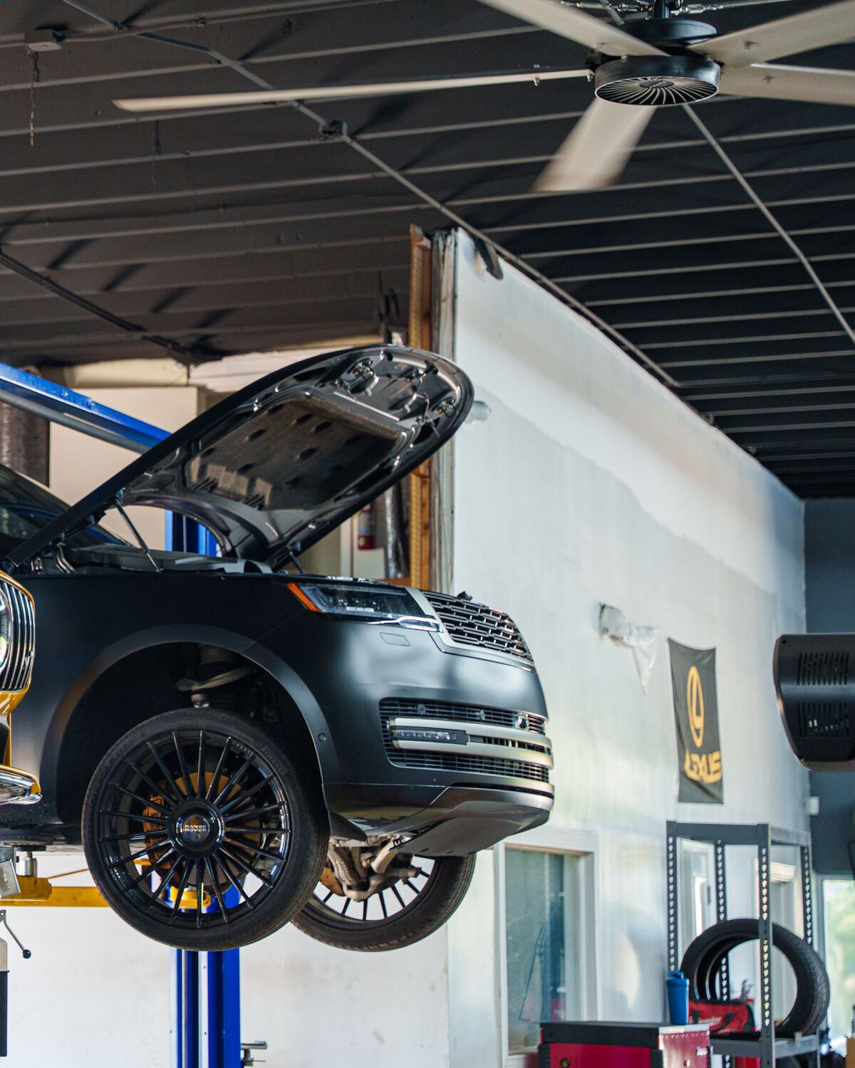 A black Range Rover with the hood open on the lift at Autobahn Auto Center