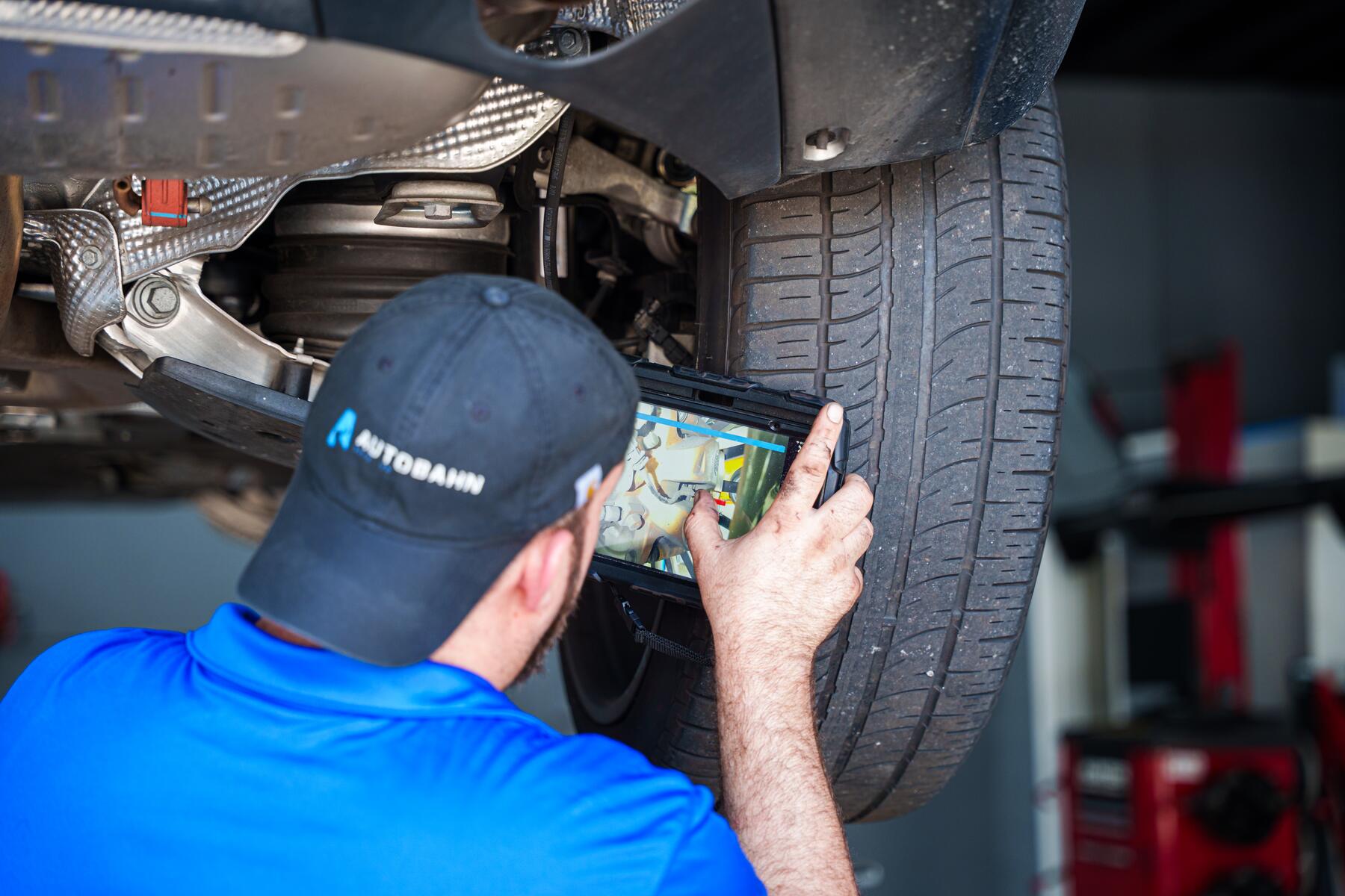 An Autobahn technician recording an inspection finding on a tablet
