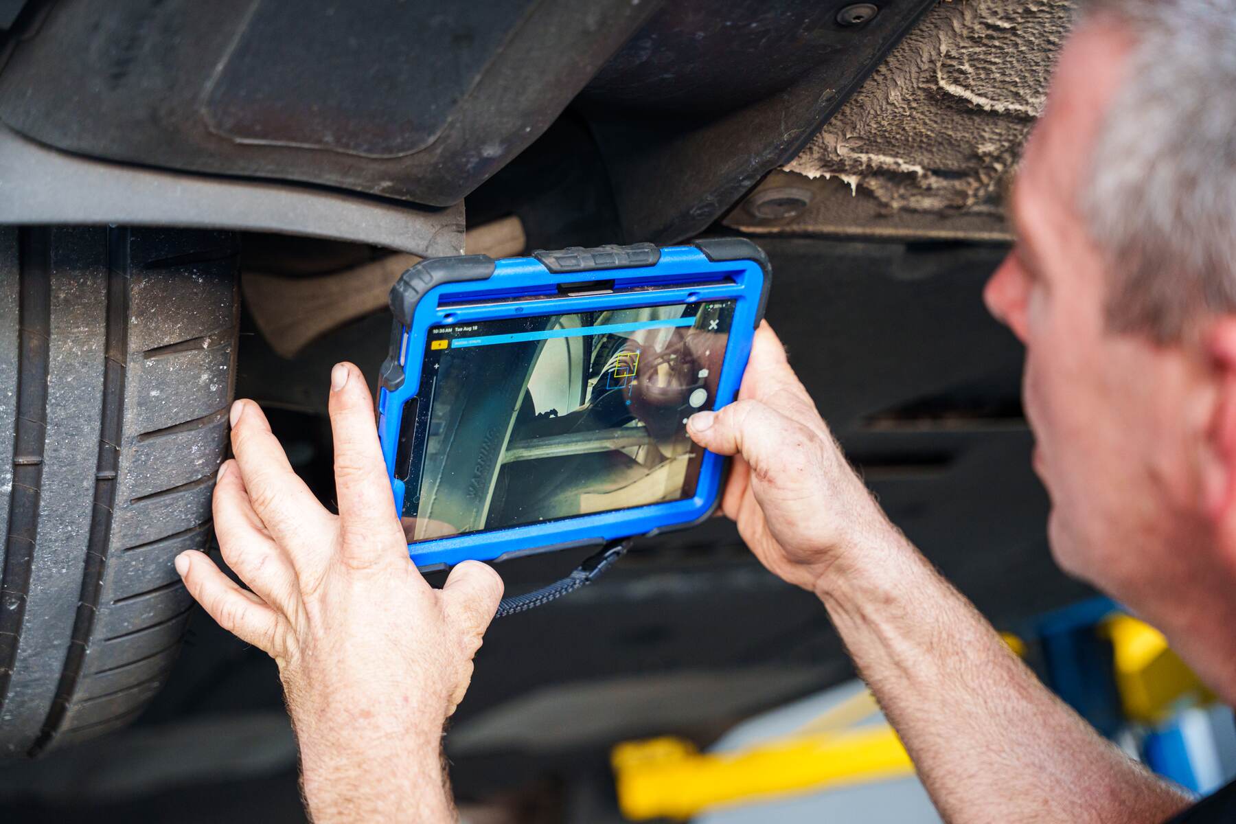An Autobahn technician photographing a finding on a tablet during a digital inspection